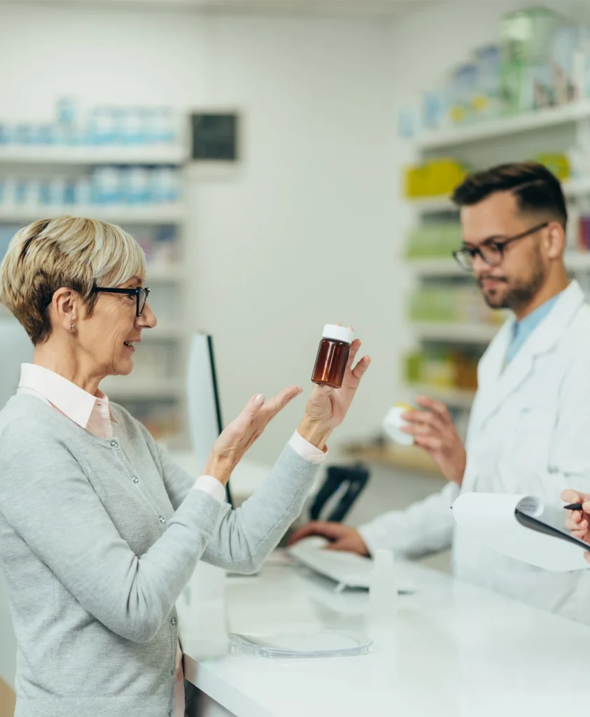 Woman holding medication, asking pharmacist if she can get a repeat prescription